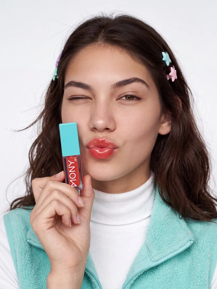 Lip gloss campaign visual: model holding the product